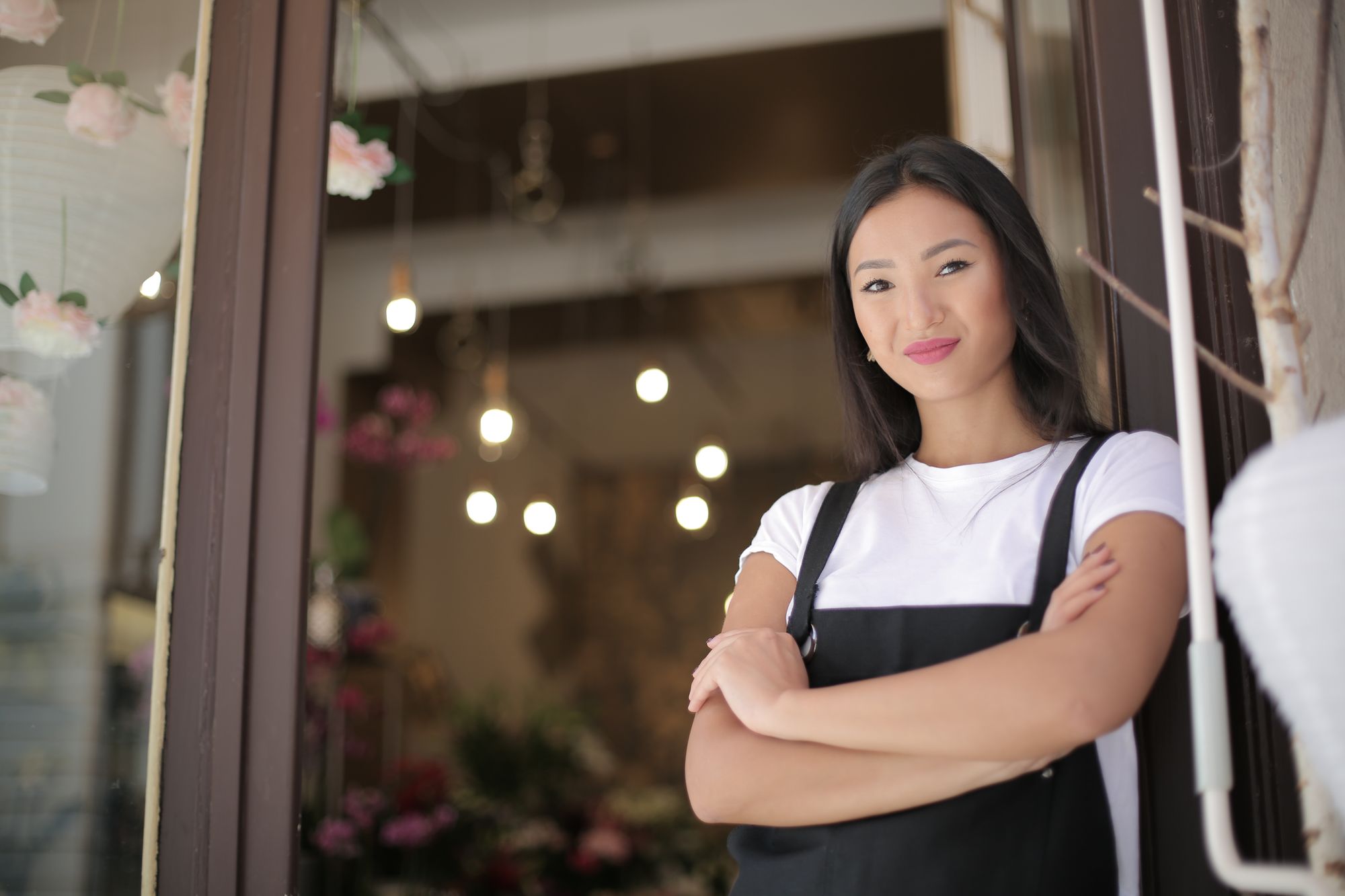 Small business owner standing confidently at the entrance of her shop